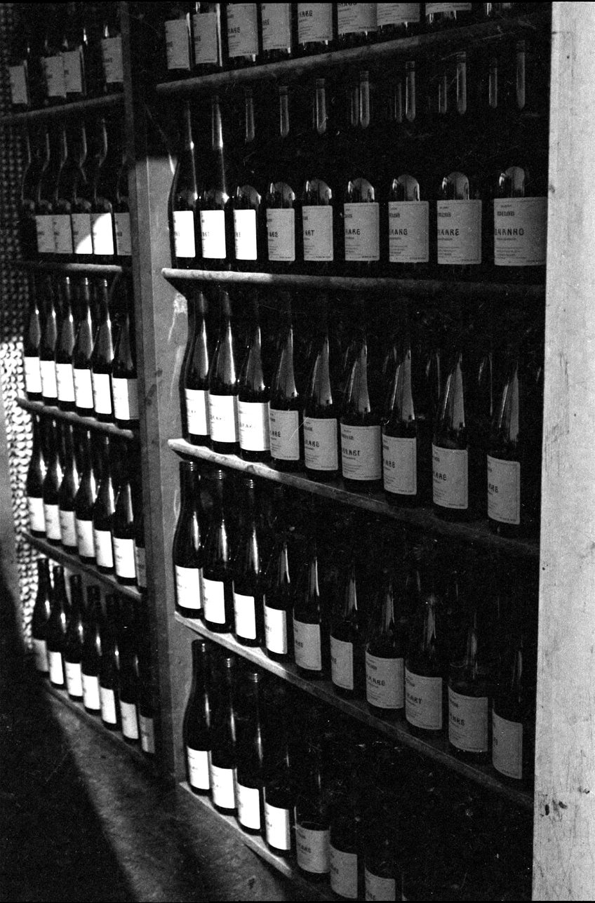 An empty shelf in a corner shop with hard light from the doorway