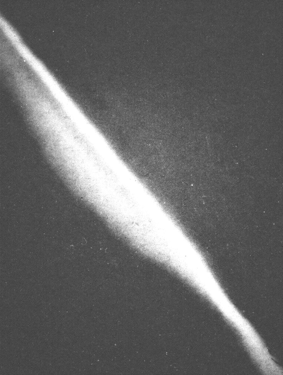 A single solid black circle printed on a white sheet of paper, minimal, paper grain