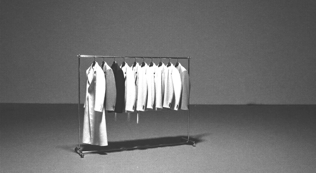 Hands arranging blank proof sheets on a light table, overhead view, strong shadow
