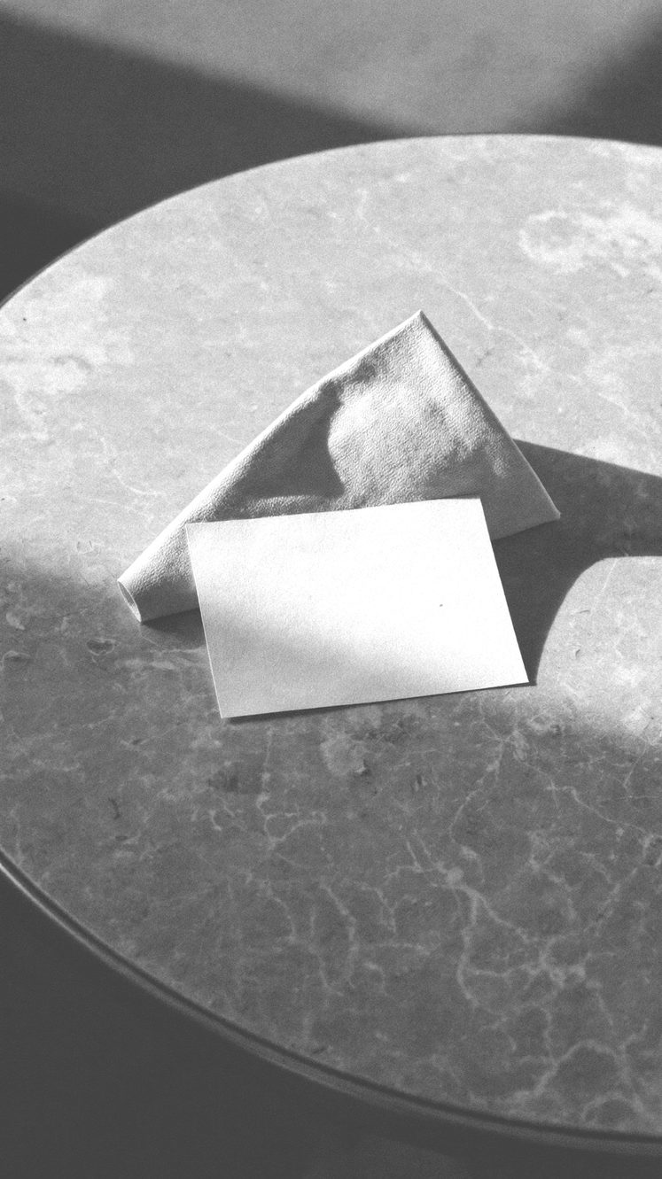 A stack of folded white towels on a stone ledge, hard side light
